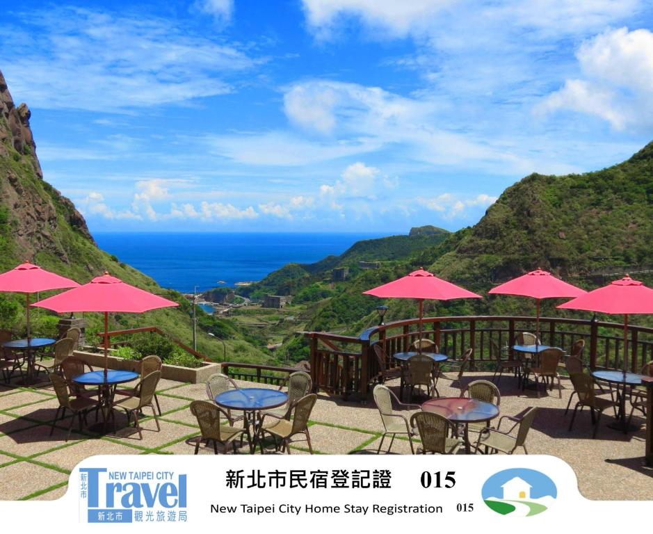 a group of tables and chairs with pink umbrellas at Formosa Arcadian Villa in Jiufen