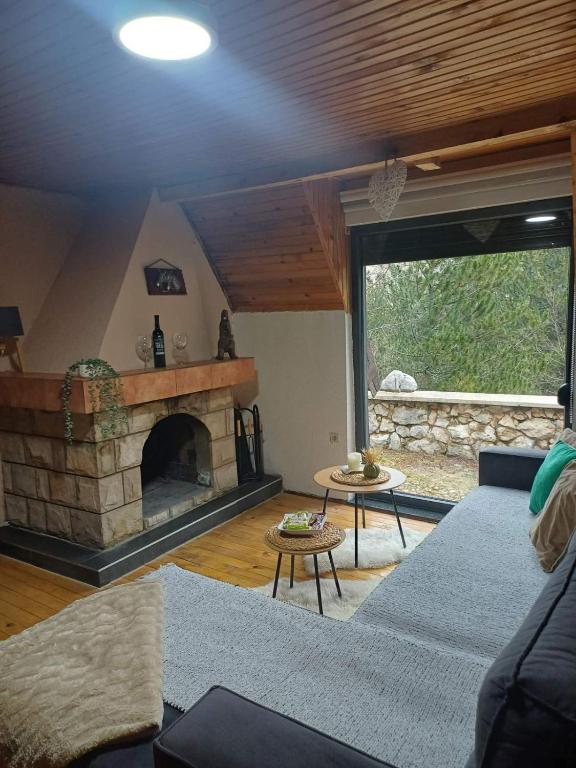 a living room with a couch and a stone fireplace at Planinska Kućica in Mostar