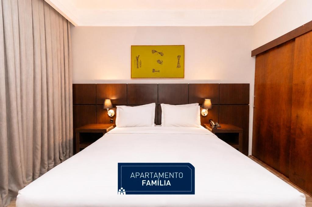 a hotel room with a bed with a sign on it at Slaviero Hotel Curitiba Shopping in Curitiba