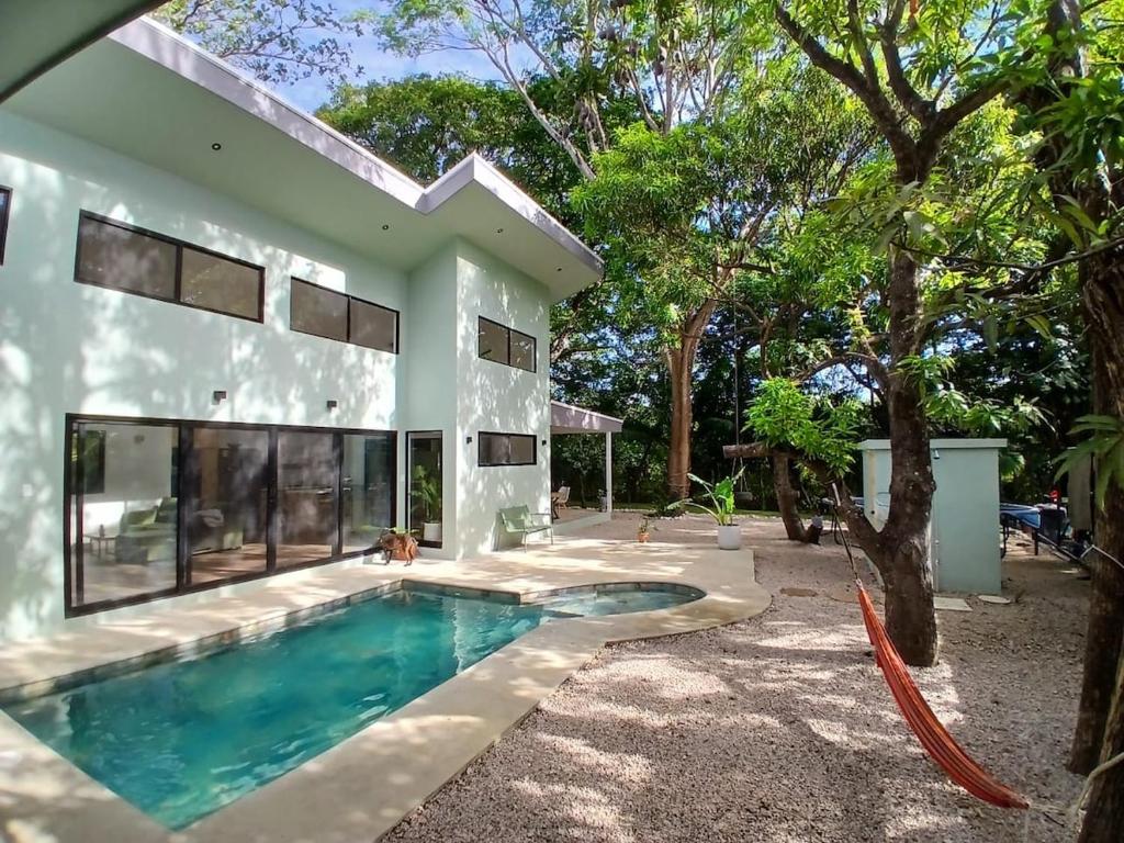 a house with a swimming pool in front of it at Between Waves and Woods in Sámara
