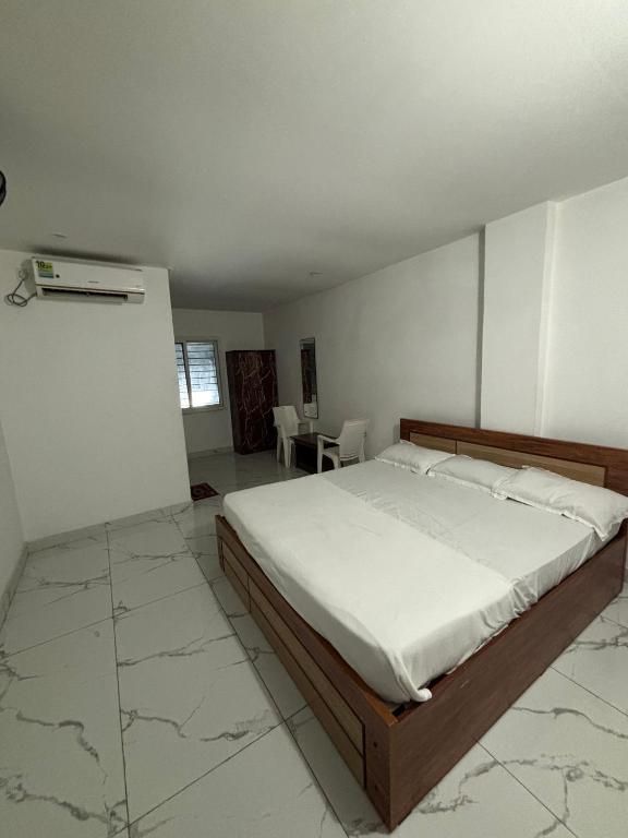 a bedroom with a bed and a table and chairs at SLV Royal Residency Hotel in Bidadi