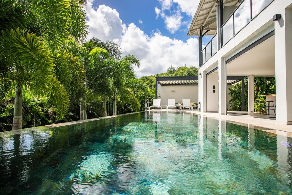 an infinity pool in the backyard of a house at Karibu House in Les Trois-Îlets