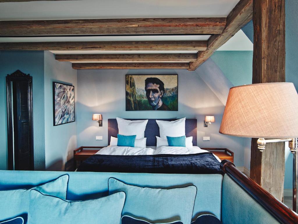a bedroom with a king sized bed with blue walls at Auberge de Temple in Johannesberg