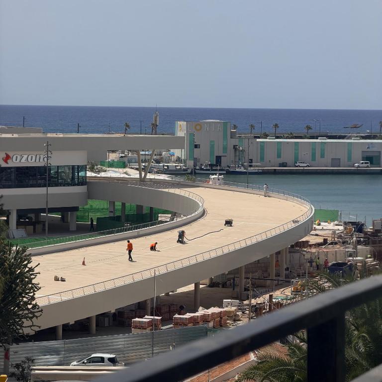 a building with a walkway in front of a beach at La Gaviota in Torrevieja