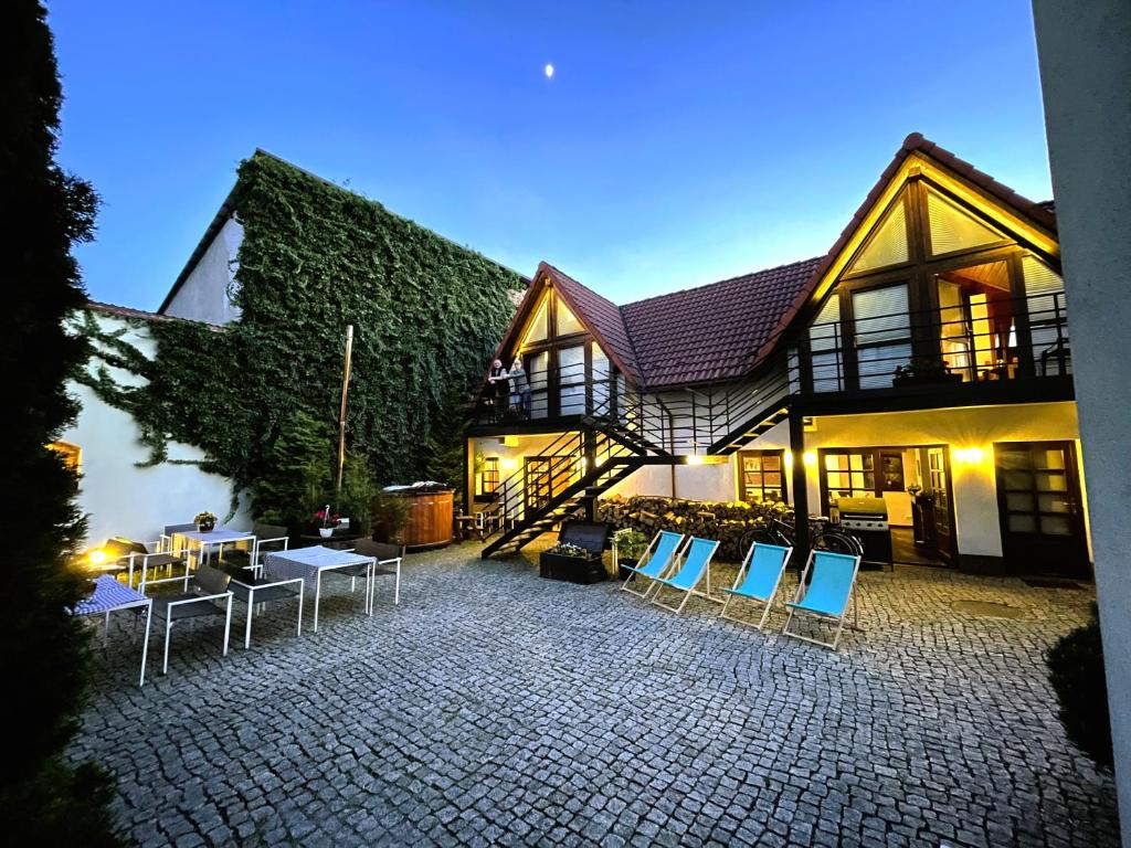 a house with chairs and tables in front of it at Hotel Beskid in Milówka