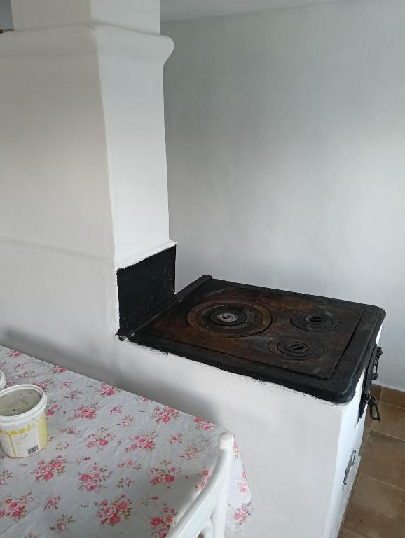 a stove in the corner of a room at Căsuța de vacanță in Bogata