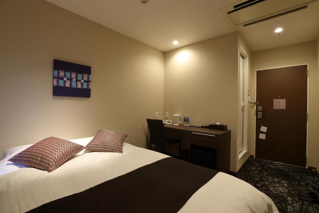 Postel nebo postele na pokoji v ubytování Osaka Teikoku Hotel
