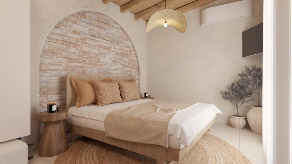 a bedroom with a bed and a brick wall at Pharos by Premium Key in Skiathos