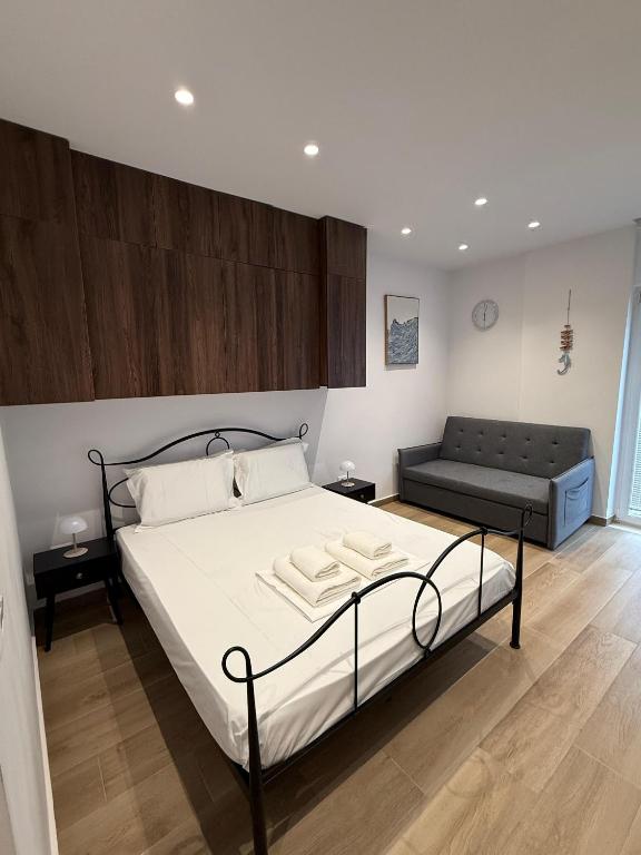 a bedroom with a bed and a couch in it at Drymades Studio Apartment in Gjilek