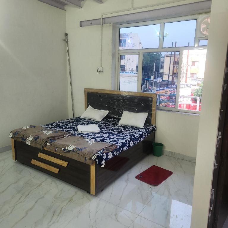 a bed with two pillows in a room with a window at Shri om paradise inn in Mathura