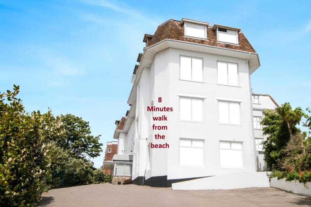 a white building with a sign that reads minutes walk from the beach at Russel Court Hotel Bournemouth Central in Bournemouth