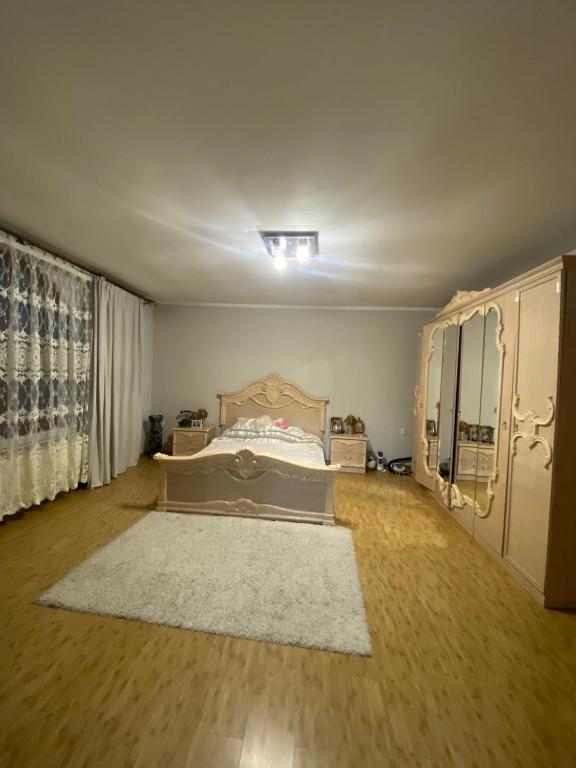 a bedroom with a bed and a white rug at Літо in Bushtyno