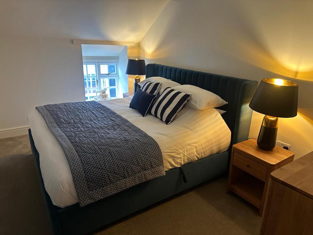 a bedroom with a bed with a blue headboard at Tafarn Penllan White Horse in Llanrwst
