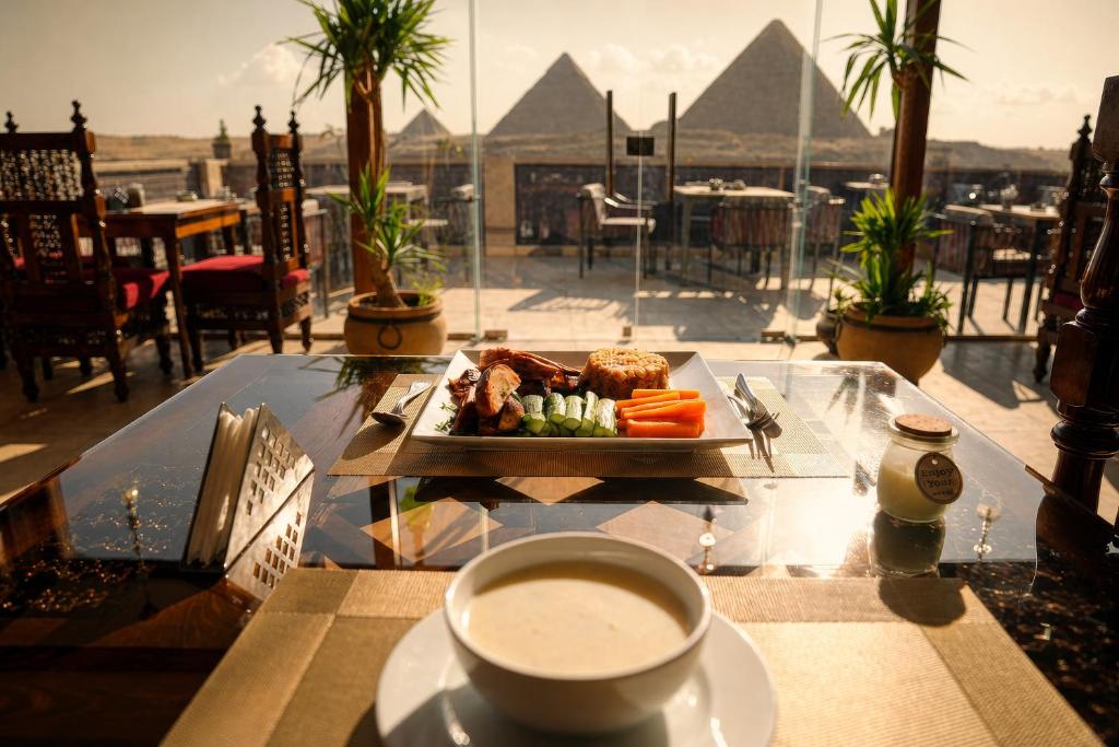 a table with a plate of food and a cup of coffee at Pyramids Hostel in Cairo