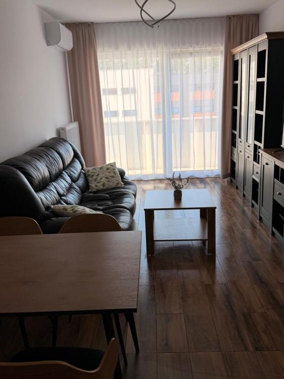 a living room with a leather couch and a coffee table at Apartament Lniany in Leszno