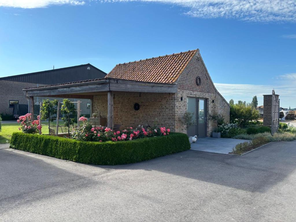 a brick house with flowers in front of it at Hoveke Paddebroek in Alveringem