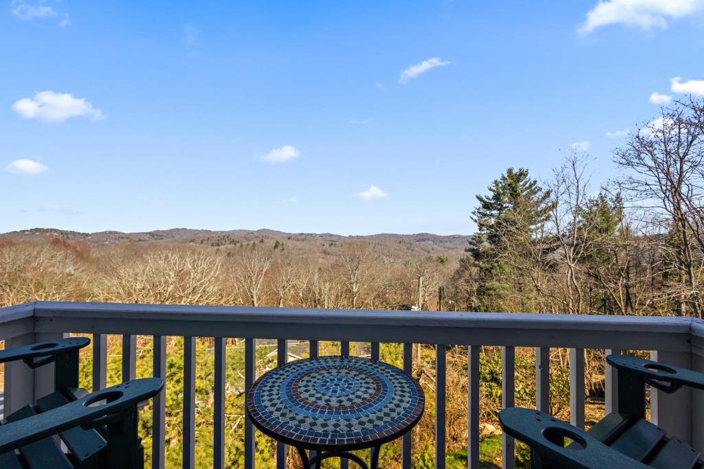 a table and chairs on a balcony with a view at A Place Apart in Blowing Rock