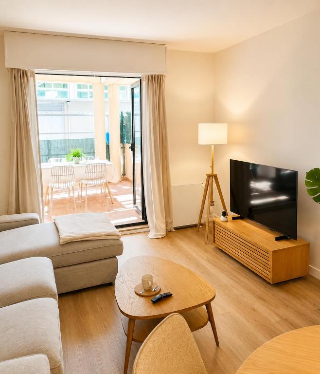 a living room with a couch and a flat screen tv at Airtegal Dunas de Cedeira in Cedeira