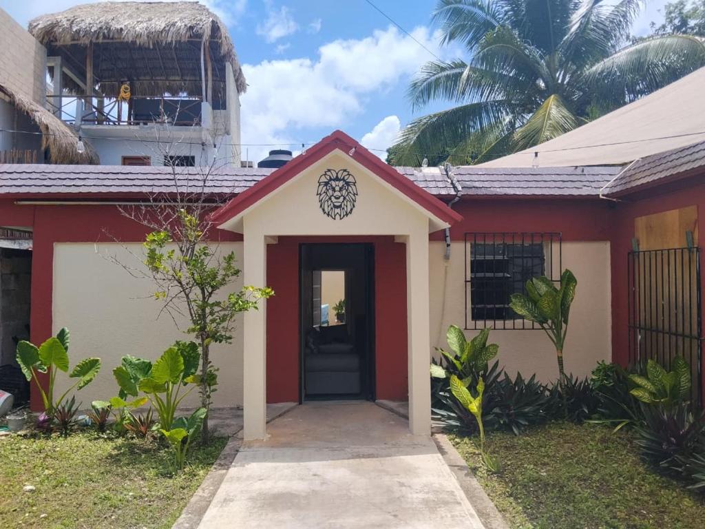 a red and white house with a black door at Casa León in Bacalar
