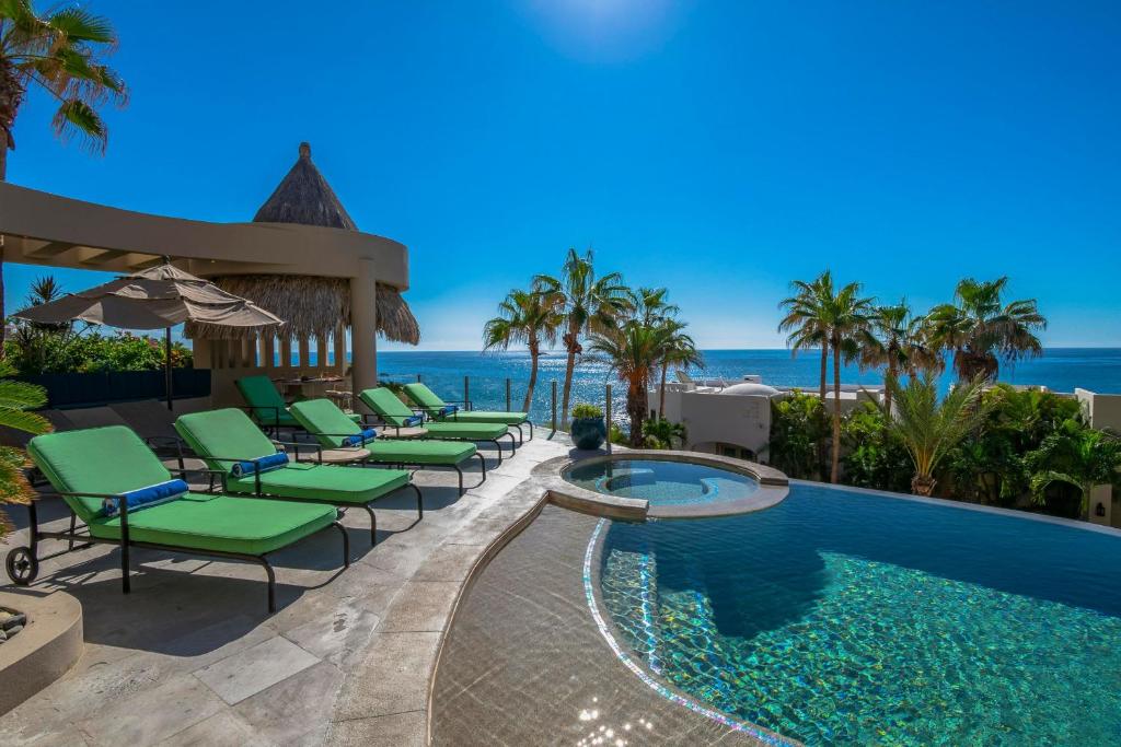 a pool with chairs and the ocean in the background at Views to El Arco, Famous Cabo San Lucas bay rock formation in El Pueblito