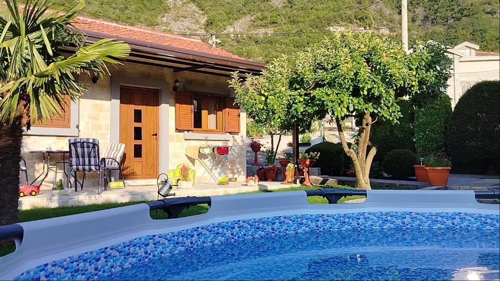 a swimming pool in front of a house at Small Stone Cottage in Virpazar