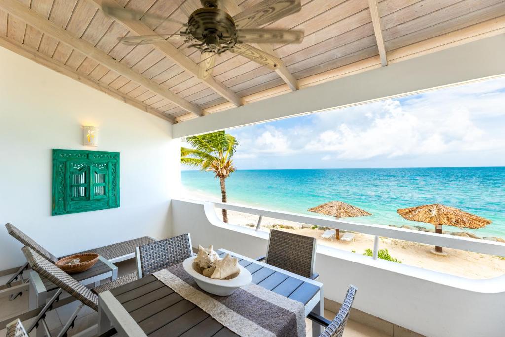a dining room with a view of the ocean at Antigua Village Beach Resort in Saint Johnʼs