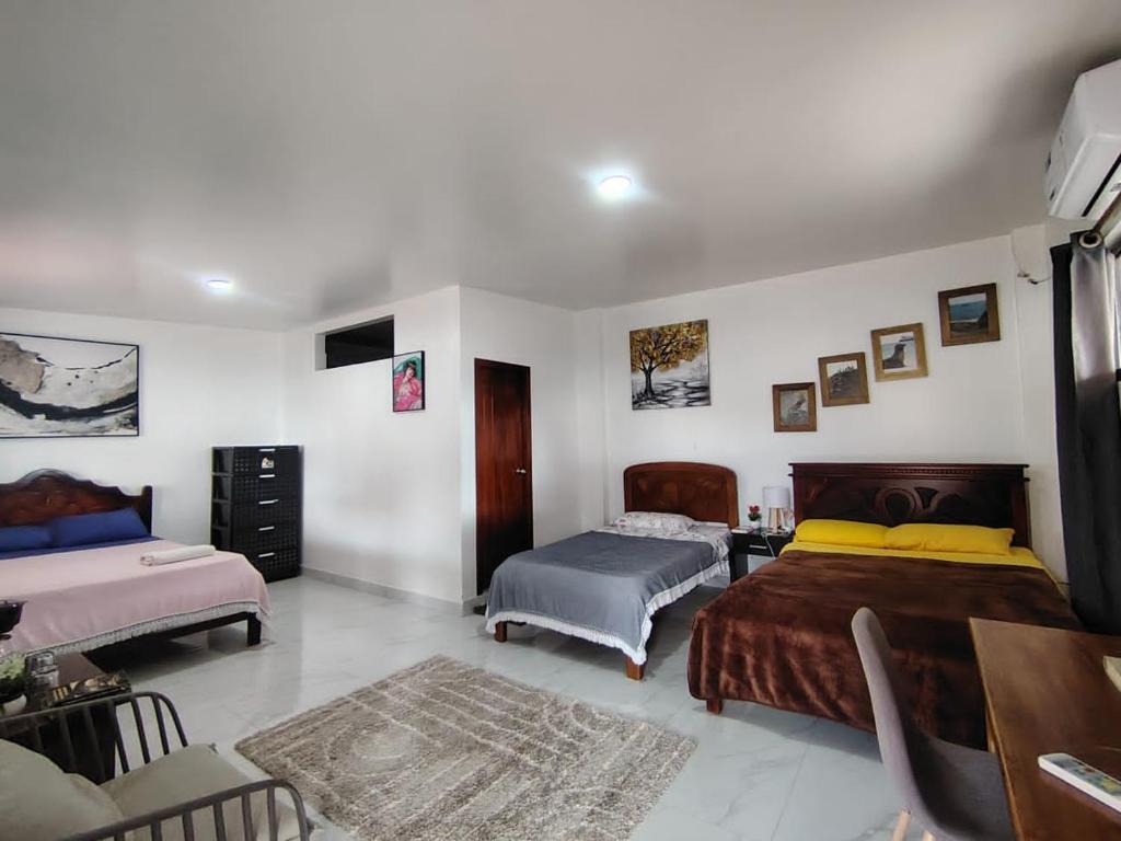 a bedroom with two beds and a table at Cuarto en galápagos in Puerto Baquerizo Moreno