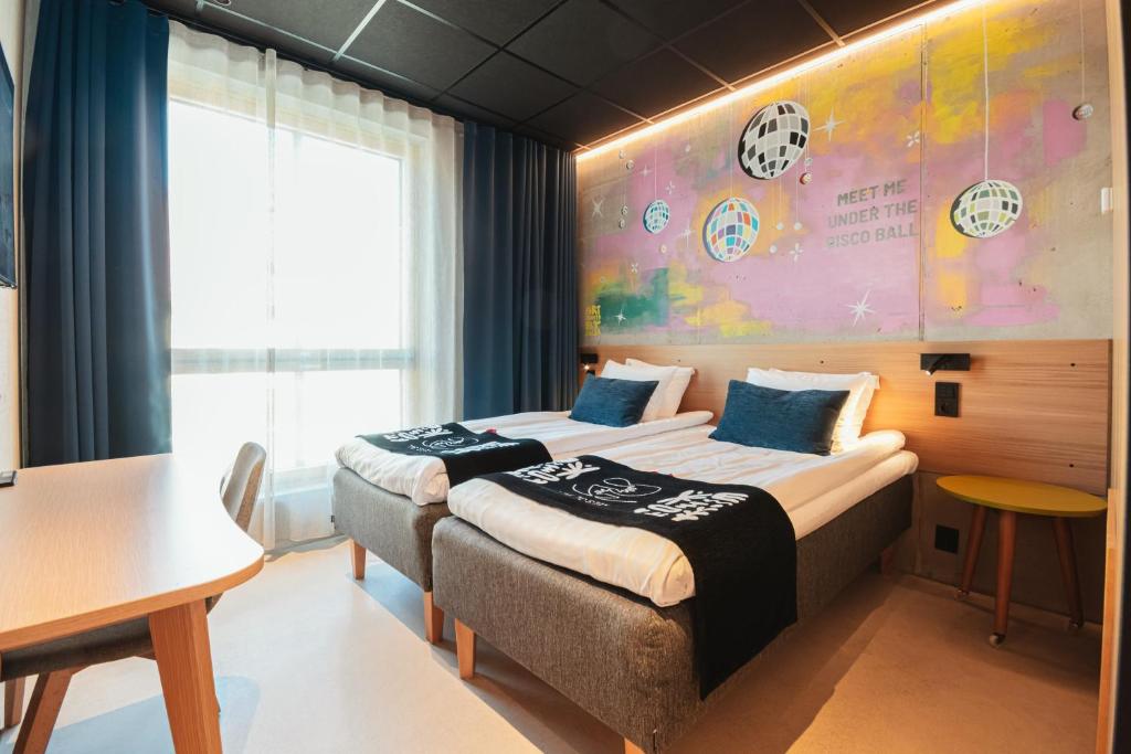 Zwei Betten in einem Zimmer mit einer Fußballwand in der Unterkunft Time Hotel, Time To Stay art & boutique in Jyväskylä