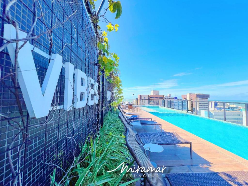 a sign on the side of a building with a swimming pool at Move - Tambaú in João Pessoa