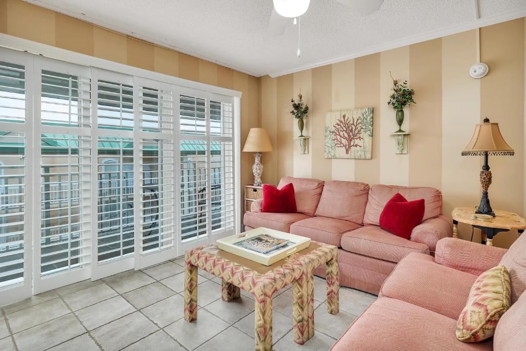a living room with a pink couch and a table at Beach Club 436 in Saint Simons Island