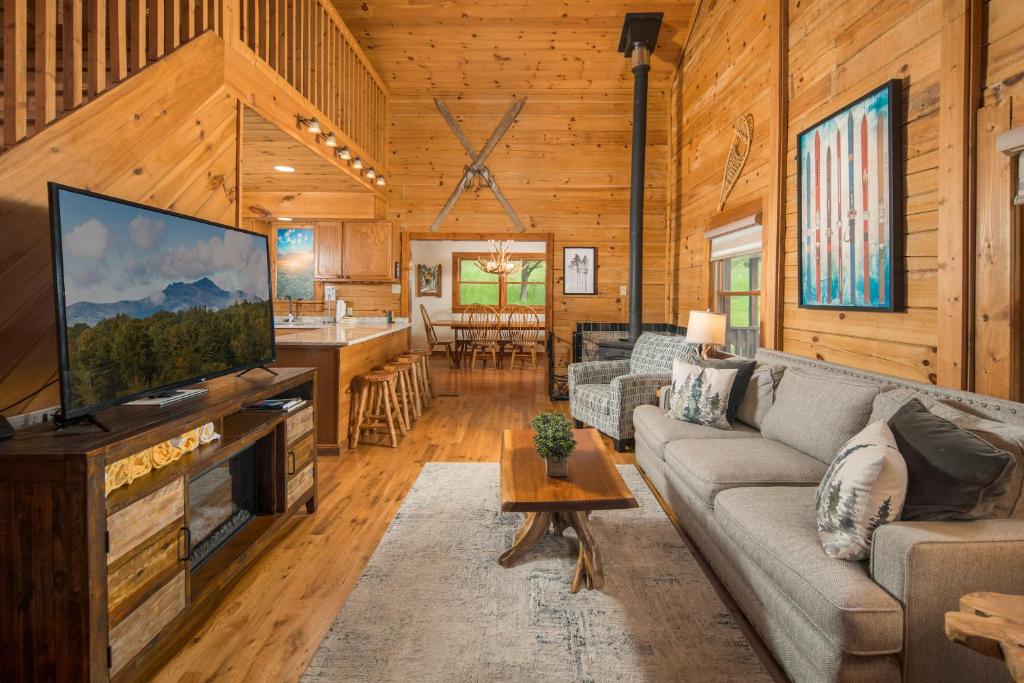 a living room with a large flat screen tv in a log cabin at Serenity Summit in Banner Elk