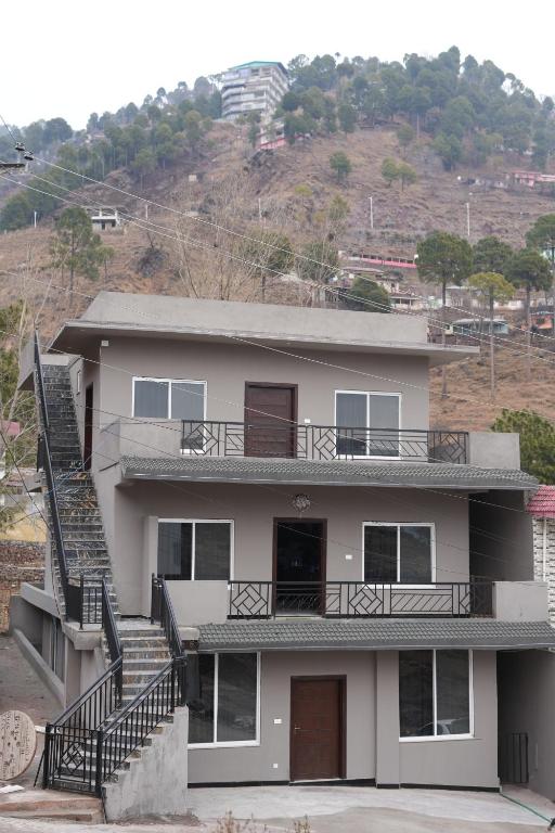 a house with a staircase in front of it at Royal Cottage in Murree in Murree