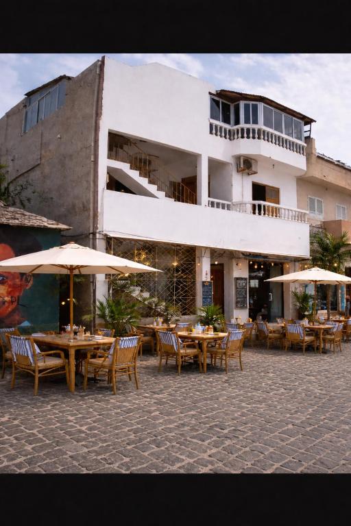 a group of tables with umbrellas in front of a building at Mistura Fina in Sal Rei