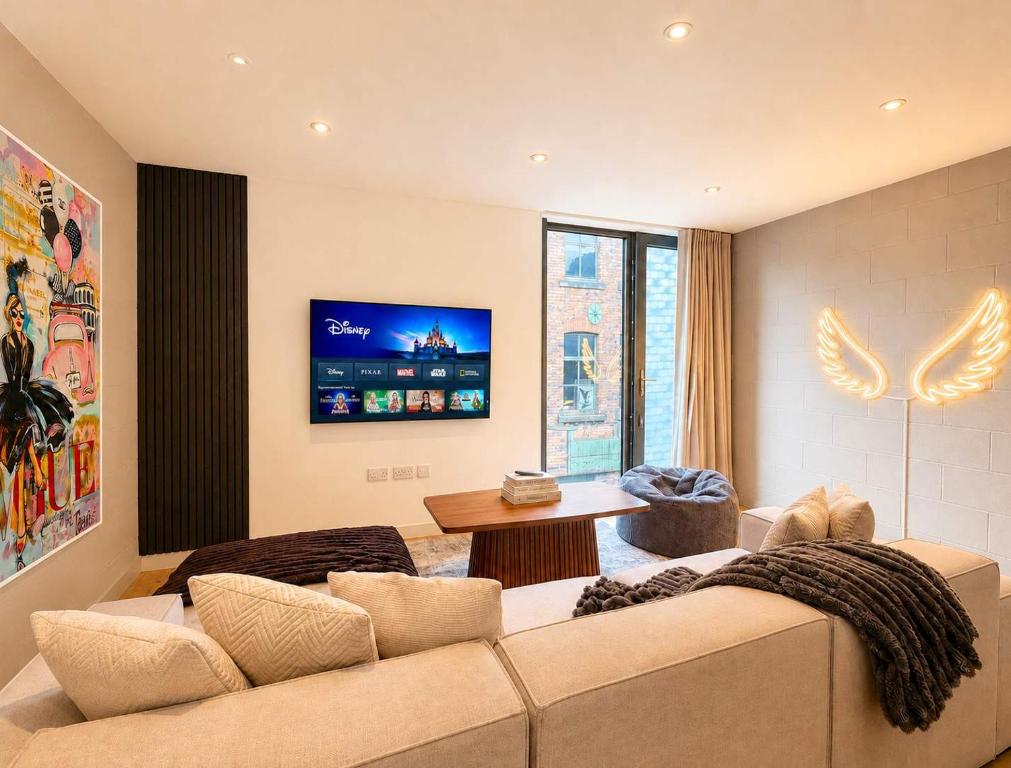 a living room with a couch and a tv at Luxury Townhouse 4BR I Roof Terrace I Free Parking in Manchester