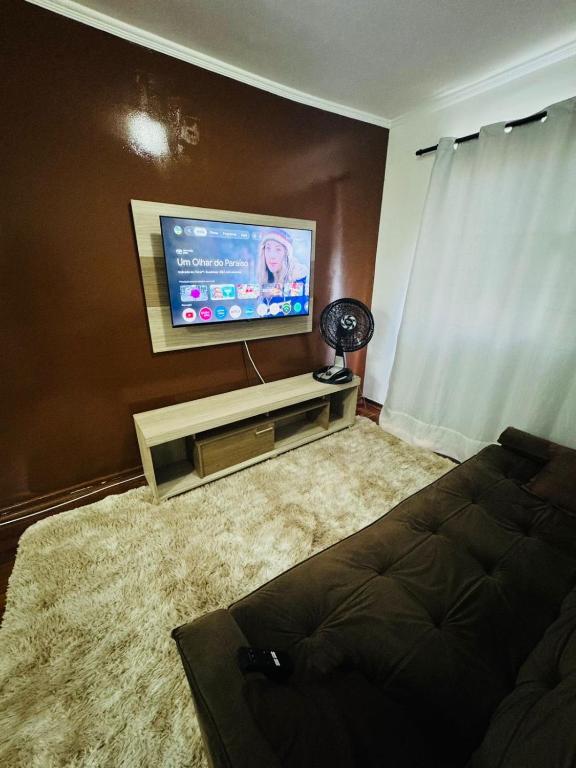 a living room with a flat screen tv and a couch at Aeroporto de Guarulhos in Guarulhos