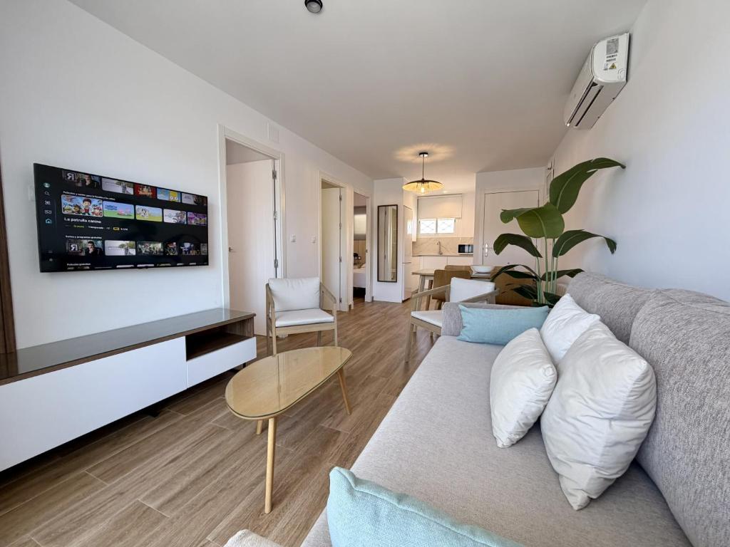 a living room with a couch and a tv at Santo Rostro Beach Apartments in Chipiona