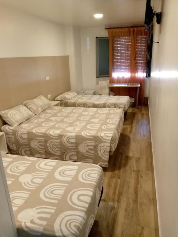 eine Reihe von vier Betten in einem Zimmer in der Unterkunft Hotel Skyline Boadilla in Alcorcón