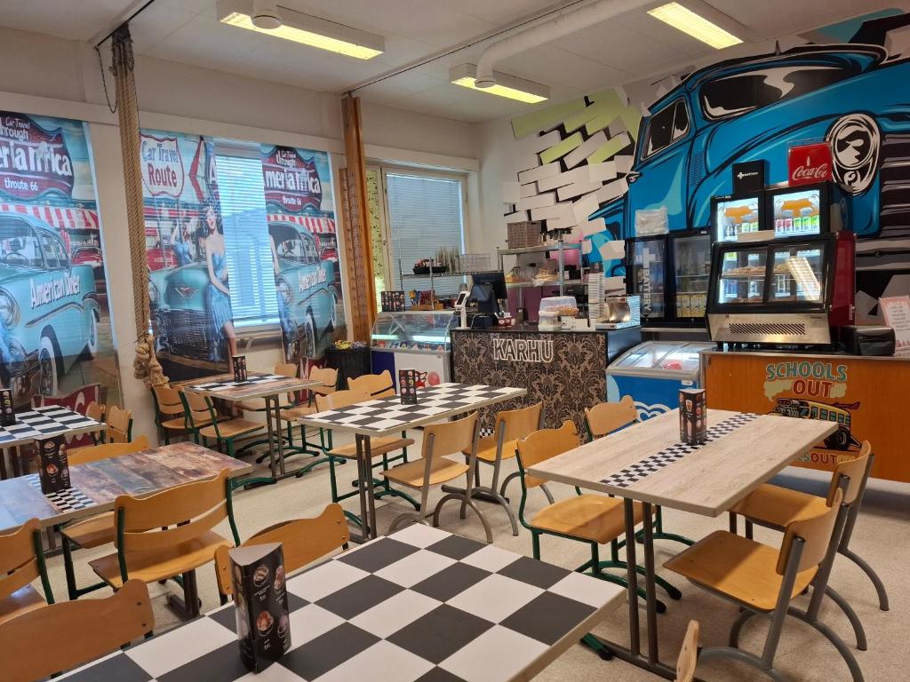 a restaurant with tables and chairs and a truck on the wall at Schools Out OY in Loviisa