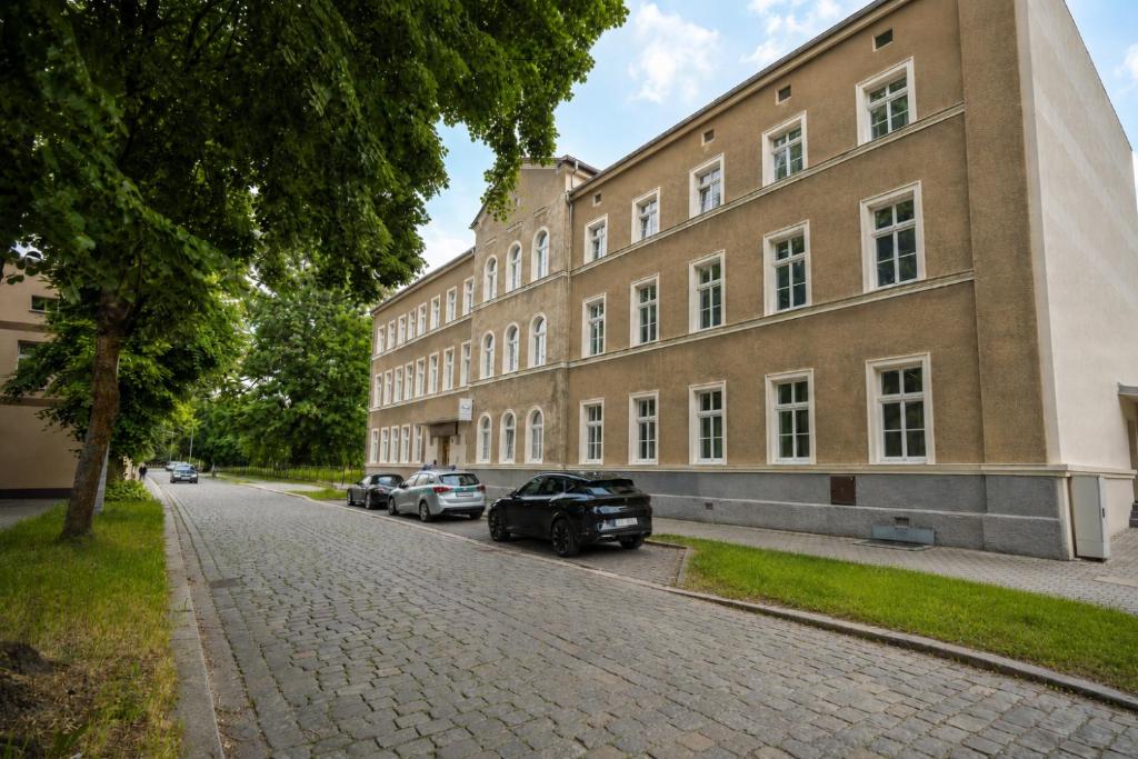 a large brick building with cars parked on the street at Nysa Gubin in Gubin