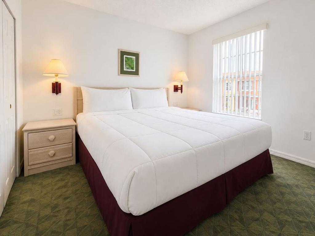 a large white bed in a room with a window at See you in Orlando in Kissimmee