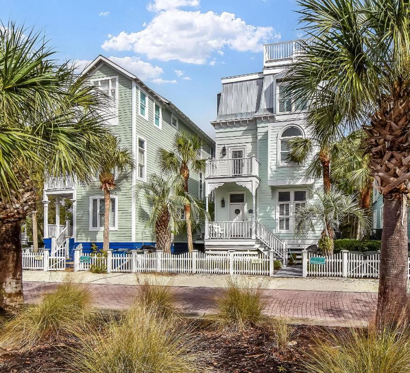 a house with palm trees in front of it at Avonlea Cottage in Saint Simons Island