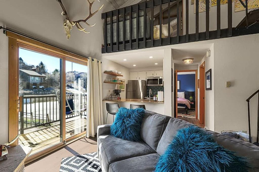 a living room with a couch with blue pillows at Restful Rockies Overlook in Steamboat Springs