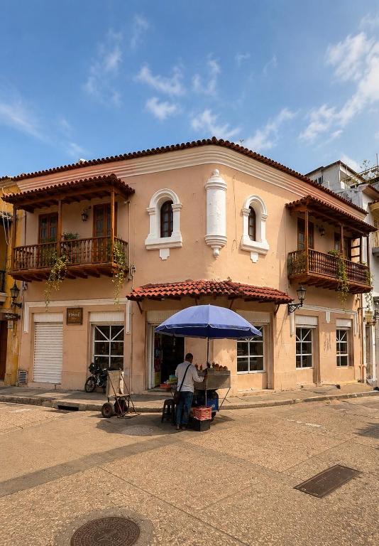 a man standing under an umbrella in front of a building at ETHNIC Thematic Hotel in Cartagena de Indias