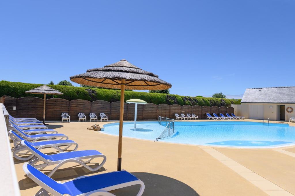 a group of chairs and umbrellas next to a swimming pool at La Dune d’Erdeven in Erdeven