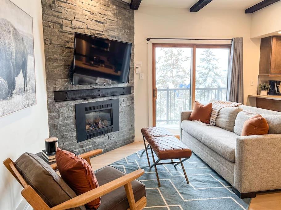 a living room with a couch and a fireplace at Alpenglow Bungalow in Steamboat Springs