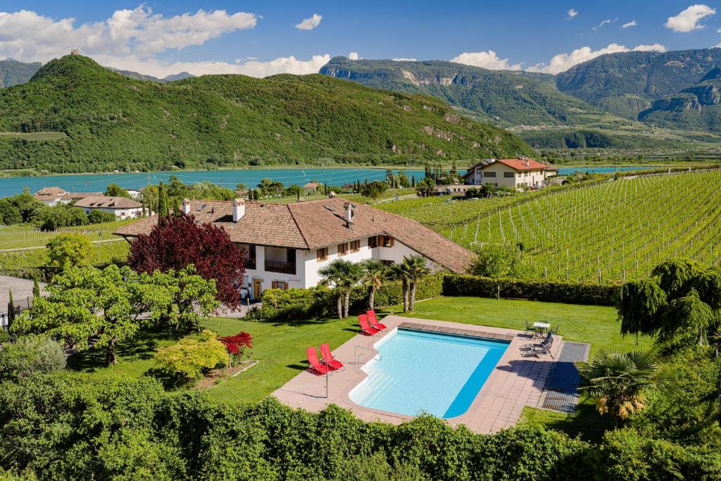 an aerial view of a house with a swimming pool and a vineyard at Kalterer See Hof in Caldaro
