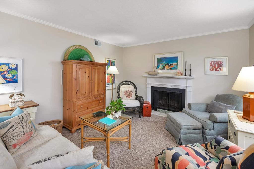 a living room with a couch and a fireplace at Oceanwood 109 in Saint Simons Island