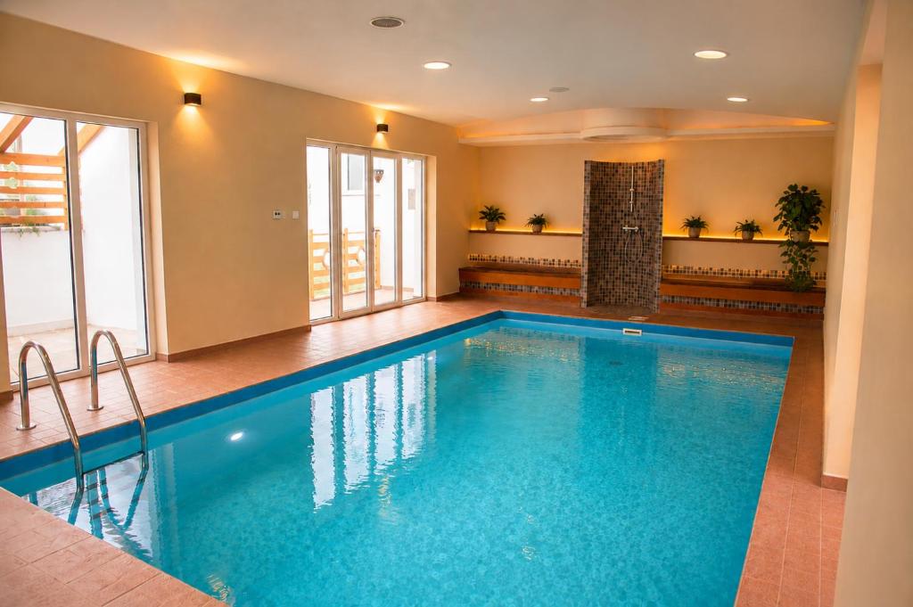 a large swimming pool in a room with at Villa Corvina in Győrújbarát