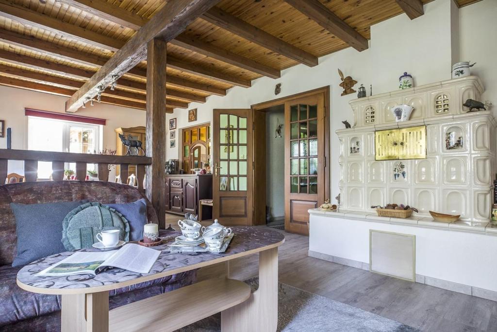 a living room with a table and a kitchen at Chatka Mysliwego Wladka in Wola Piotrowa