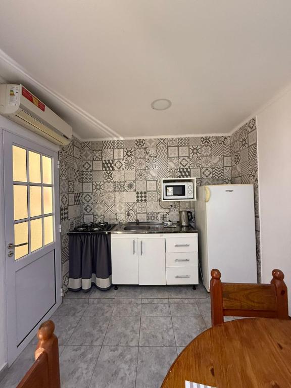 a kitchen with a white refrigerator and a table at La Seven Dpto Turístico in Colón